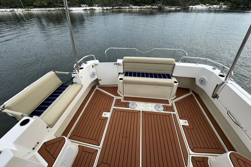 Slide: The Image of 2022 Ranger Tugs R-31 CB boat deck with cushioned seating and wood-style flooring. - 19