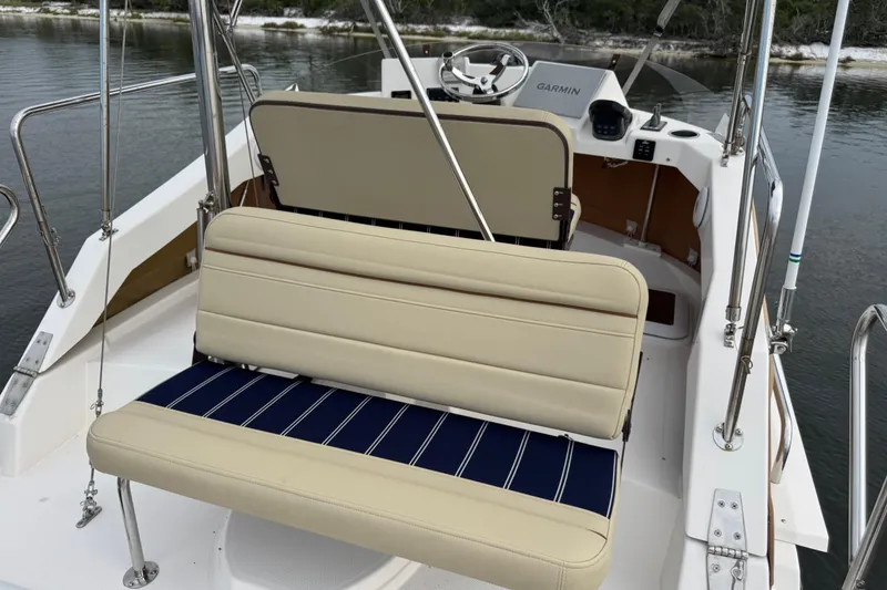 Slide: The Image of 2022 Ranger Tugs R-31 CB boat interior with beige seating and Garmin navigation. - 28
