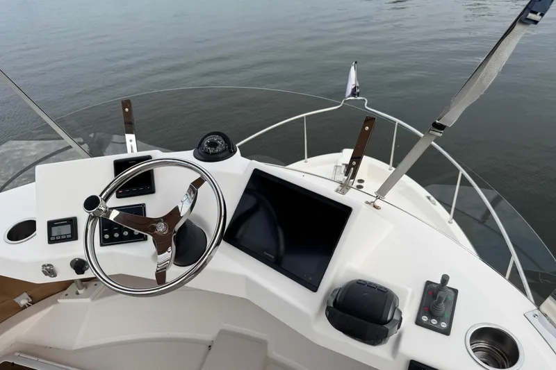 Slide: The Image of 2022 Ranger Tugs R-31 CB helm with steering wheel, controls, and navigation display. - 29