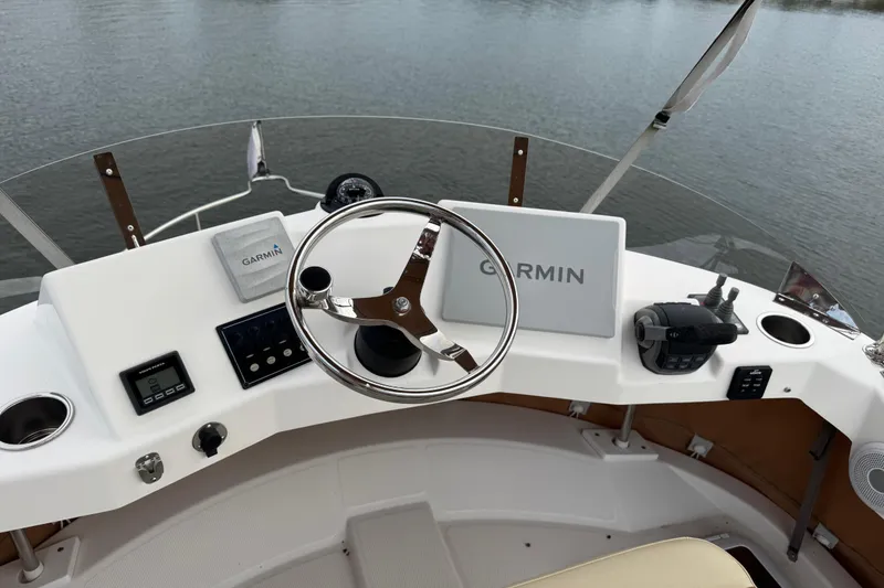 Slide: The Image of 2022 Ranger Tugs R-31 CB helm with Garmin navigation system on calm water. - 35
