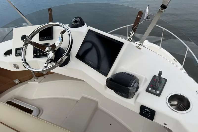 Slide: The Image of Helm of 2022 Ranger Tugs R-31 CB with steering wheel and navigation controls. - 39
