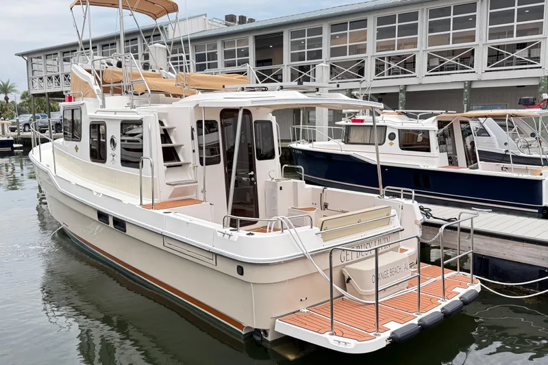 Slide: The Image of 2022 Ranger Tugs R-31 CB boat docked at marina, showcasing elegant design and spacious deck. - 4