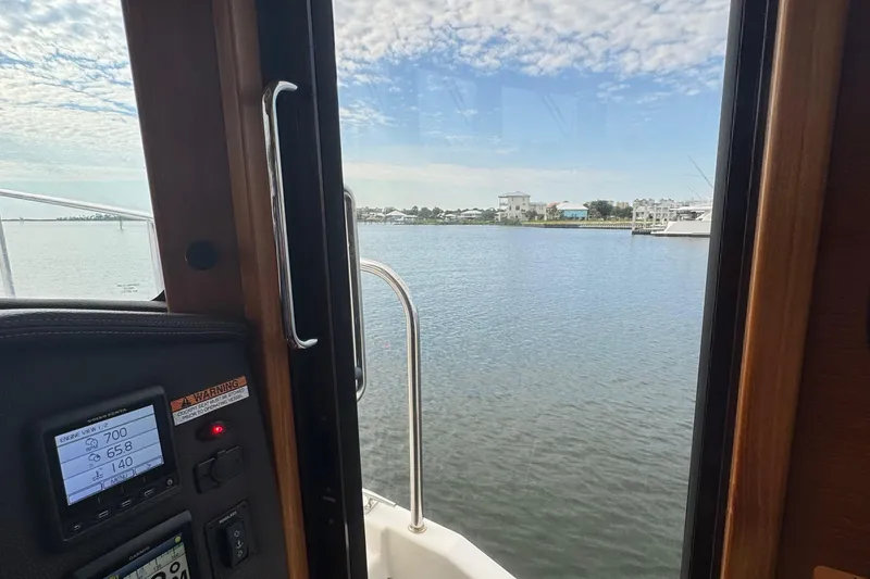 Slide: The Image of View from inside a 2022 Ranger Tugs R-31 CB, overlooking a serene waterfront. - 46