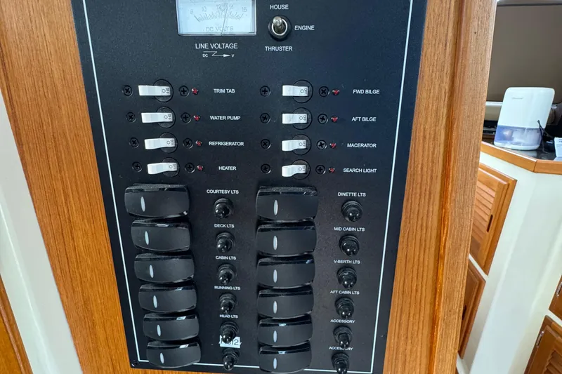 Slide: The Image of Electrical control panel on 2022 Ranger Tugs R-31 CB boat, featuring various switches and gauges. - 54