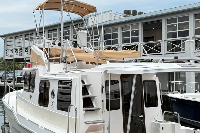 Slide: The Image of 2022 Ranger Tugs R-31 CB boat docked near a modern building. - 6