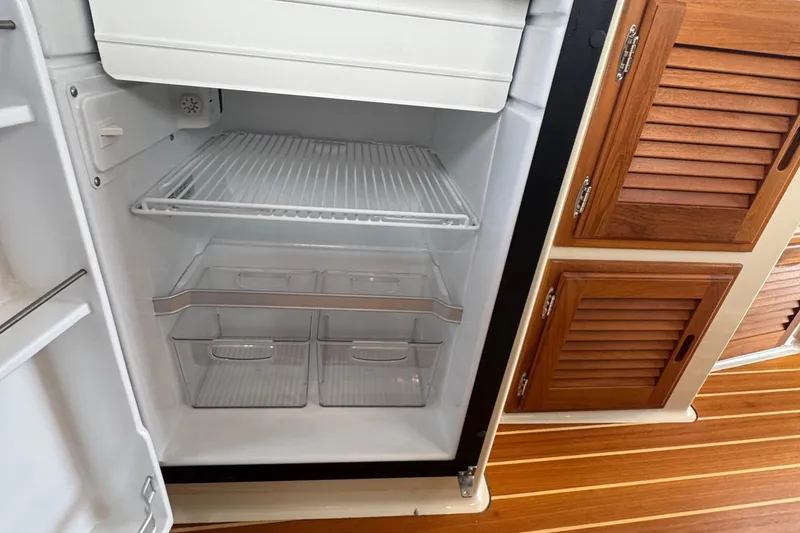 Slide: The Image of Fridge interior on 2022 Ranger Tugs R-31 CB boat with wooden cabinets. - 63