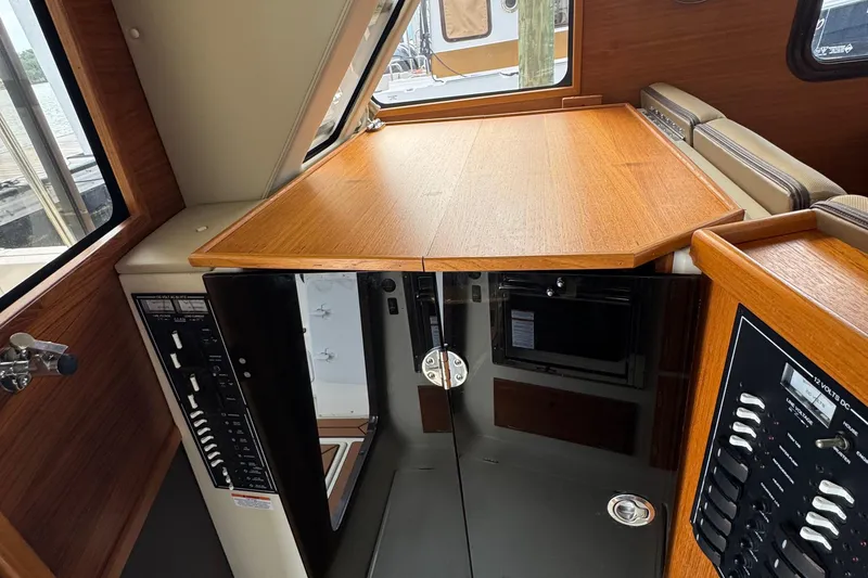 Slide: The Image of 2022 Ranger Tugs R-31 CB interior with wood finish and control panels. - 66