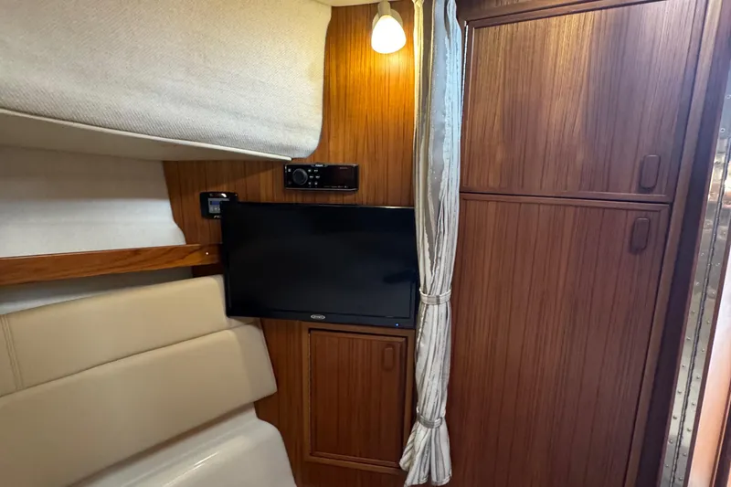 Slide: The Image of Interior of 2022 Ranger Tugs R-31 CB with TV, wood paneling, and ambient lighting. - 69