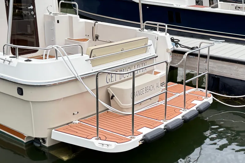 Slide: The Image of 2022 Ranger Tugs R-31 CB boat with wooden deck and railings at a marina. - 7