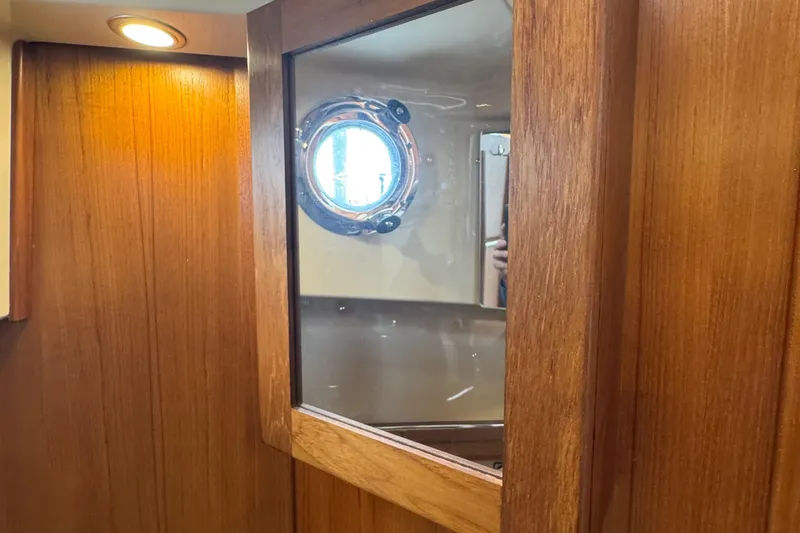 Slide: The Image of Interior of 2022 Ranger Tugs R-31 CB with wooden paneling and porthole window. - 76