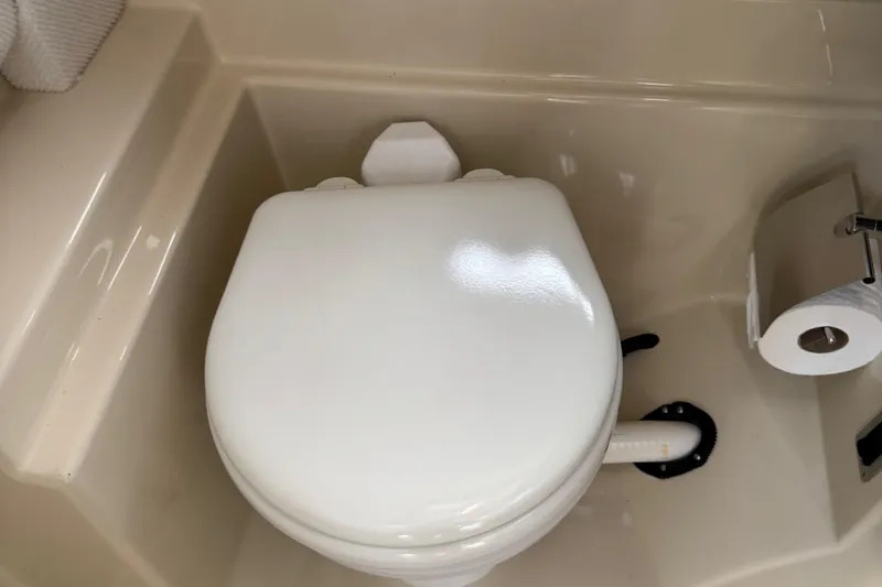 Slide: The Image of 2022 Ranger Tugs R-31 CB boat bathroom with toilet and toilet paper holder. - 78