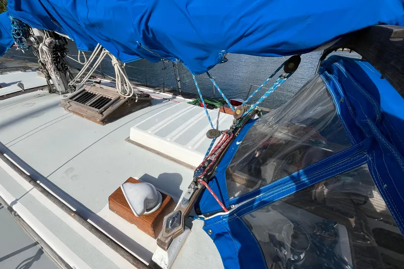 Slide: The Image of 1982 Tayana 37 sailboat deck with blue canvas cover and rigging details. - 11