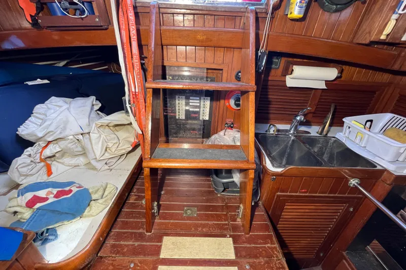 Slide: The Image of Interior of 1982 Tayana 37 sailboat with wooden ladder, sink, and storage area. - 25