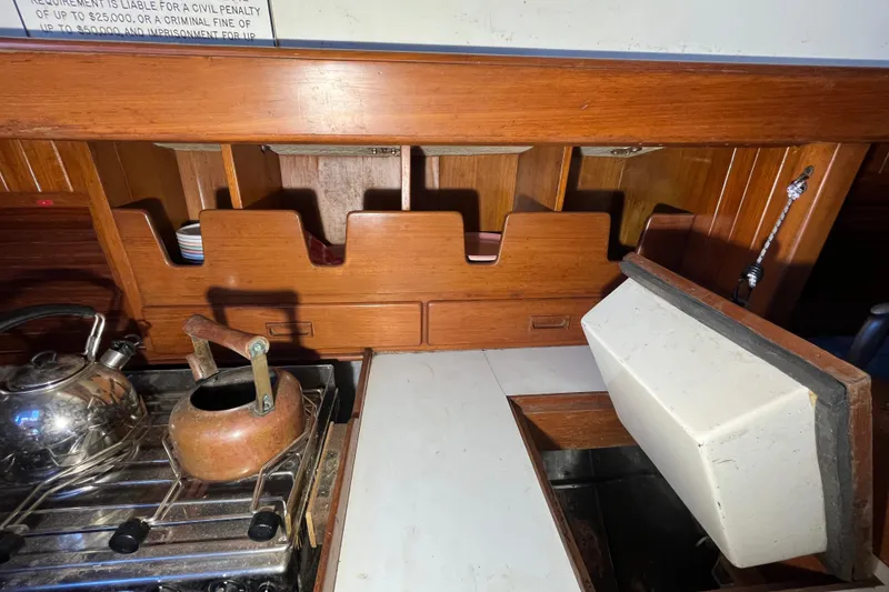 Slide: The Image of Interior of 1982 Tayana 37 sailboat galley with stove and wooden cabinetry. - 31