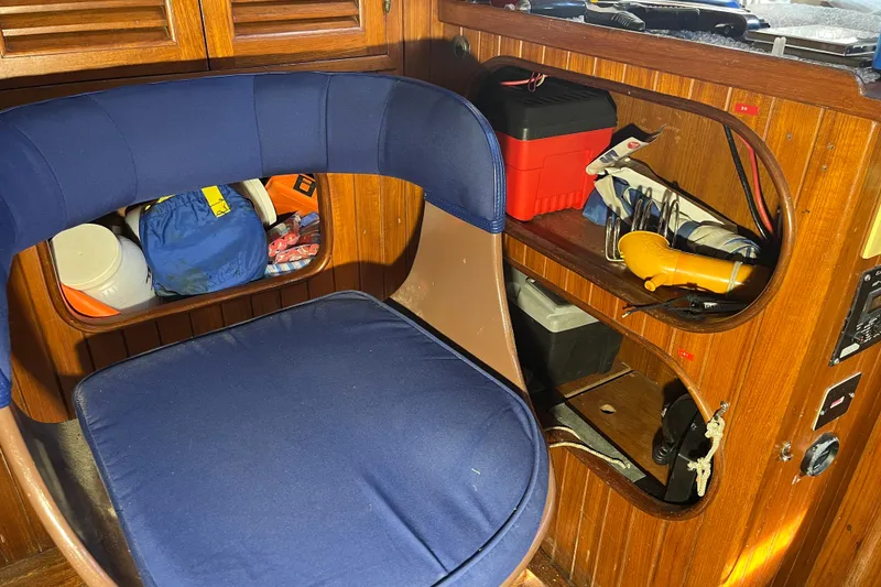 Slide: The Image of Interior of 1982 Tayana 37 sailboat with blue seat and wooden storage shelves. - 38