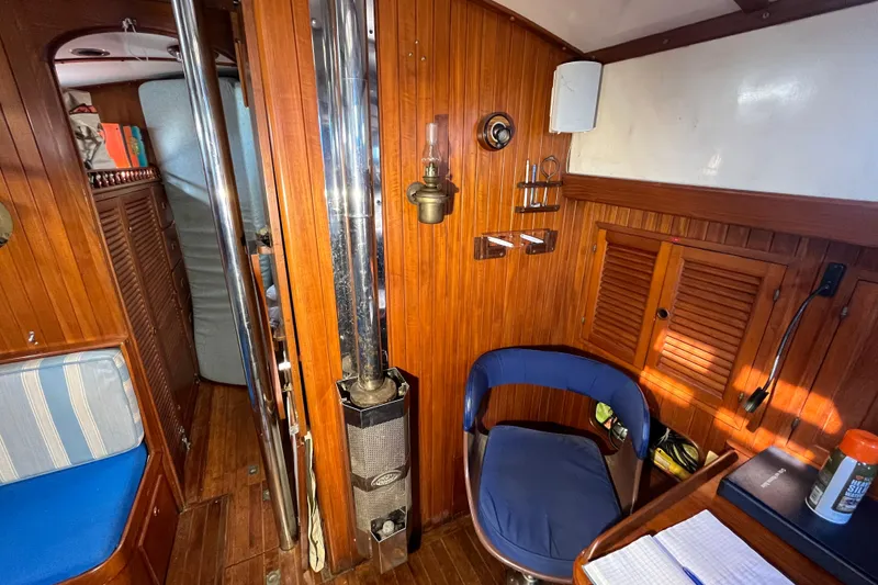 Slide: The Image of Cozy 1982 Tayana 37 yacht interior with wood paneling, seating, and nautical decor. - 43