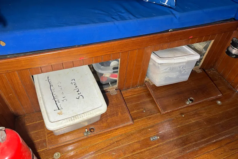 Slide: The Image of Storage compartments on a 1982 Tayana 37 sailboat with blue cushion seating. - 49
