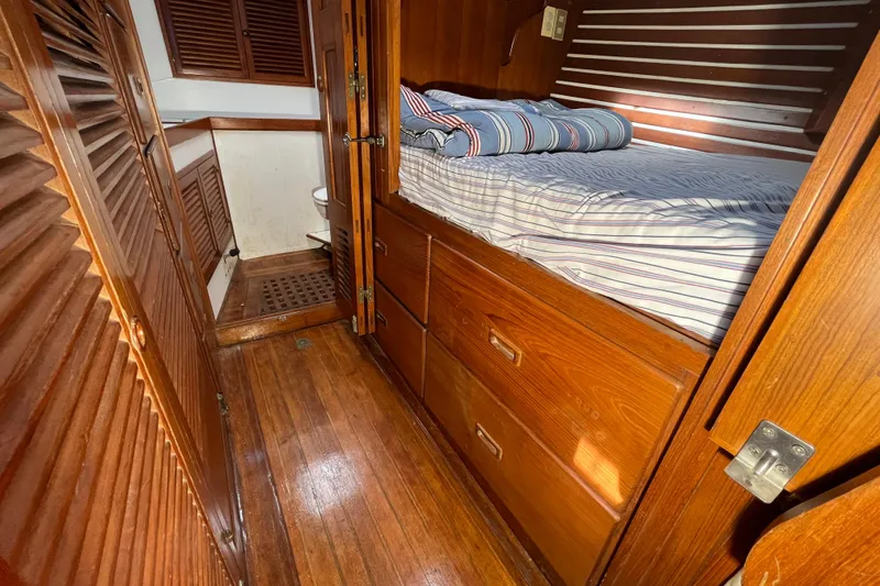 Slide: The Image of Cozy cabin interior of 1982 Tayana 37 sailboat with wooden furnishings and striped bedding. - 55