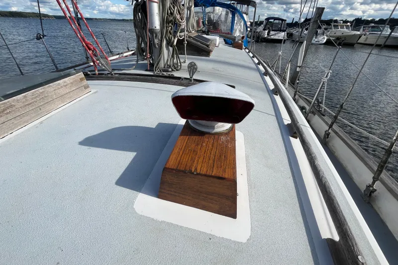 Slide: The Image of 1982 Tayana 37 sailboat deck with wooden details and marina view. - 6