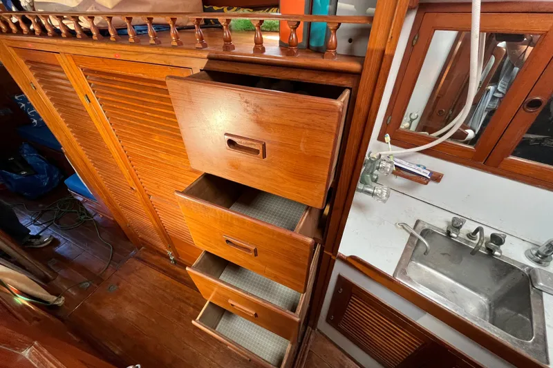 Slide: The Image of Interior of 1982 Tayana 37 sailboat with wooden drawers and compact sink area. - 65