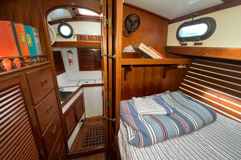 Slide: The Image of Cozy interior of 1982 Tayana 37 sailboat with wood paneling and striped bedding. - 66