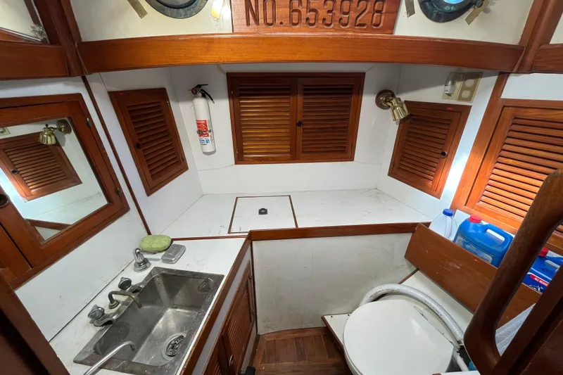 Slide: The Image of 1982 Tayana 37 yacht bathroom with wooden cabinets, sink, and toilet. - 68