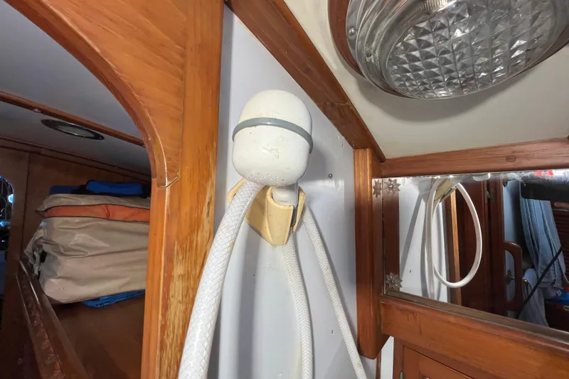 Slide: The Image of 1982 Tayana 37 interior with wooden trim, showerhead, and storage area. - 71