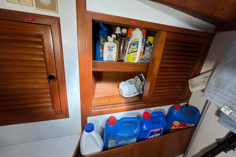 Slide: The Image of Storage area on a 1982 Tayana 37 yacht with cleaning supplies and containers. - 73