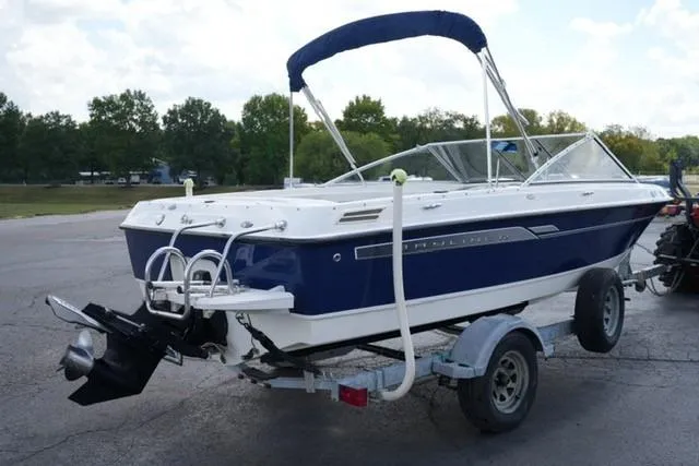 Slide: The Image of 2006 Bayliner 195 Classic boat on trailer, blue and white design, parked outdoors. - 3
