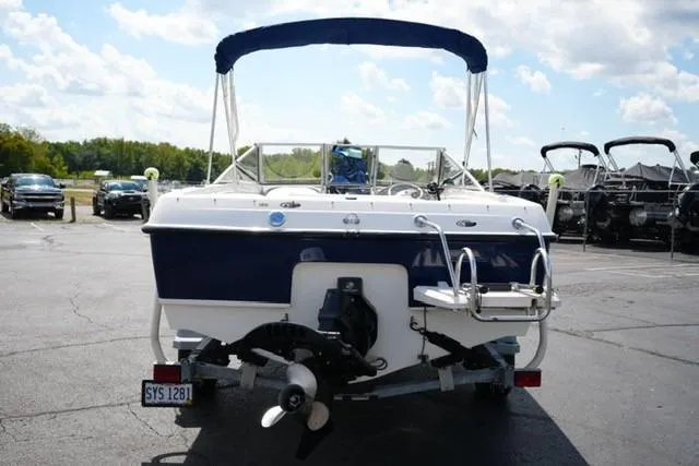 Slide: The Image of 2006 Bayliner 195 Classic boat, rear view, parked outdoors under a blue sky. - 4