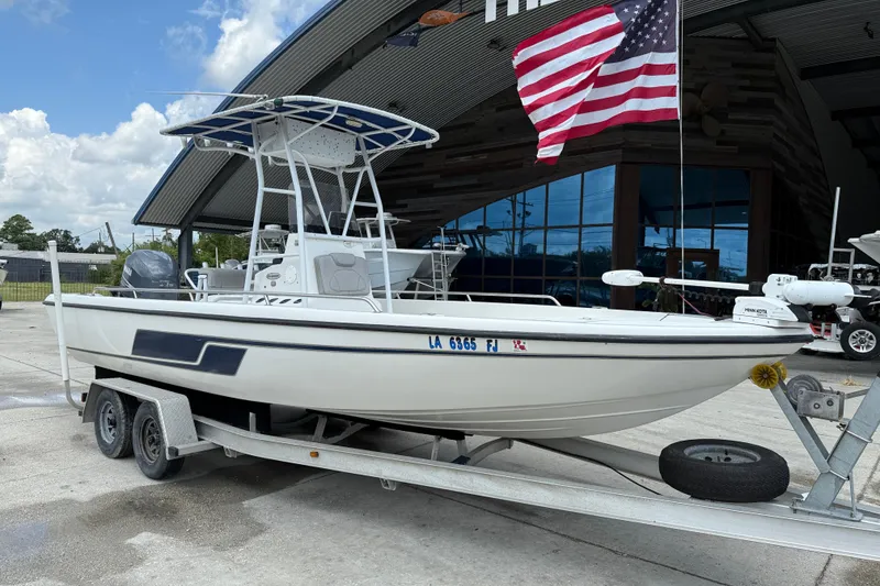 Slide: The Image of 2003 Skeeter ZX2400 boat on trailer with Minn Kota motor, parked outdoors. - 2