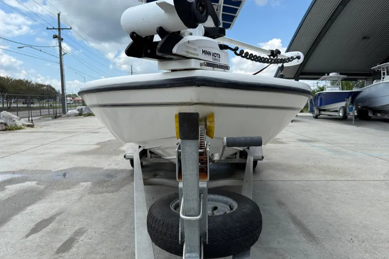 Slide: The Image of 2003 Skeeter ZX2400 boat on trailer with Minn Kota motor, parked outdoors. - 3