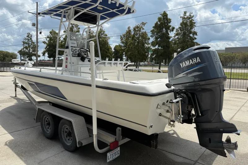 Slide: The Image of 2003 Skeeter ZX2400 boat with 225 horsepower engine, parked outdoors under a cloudy sky. - 5