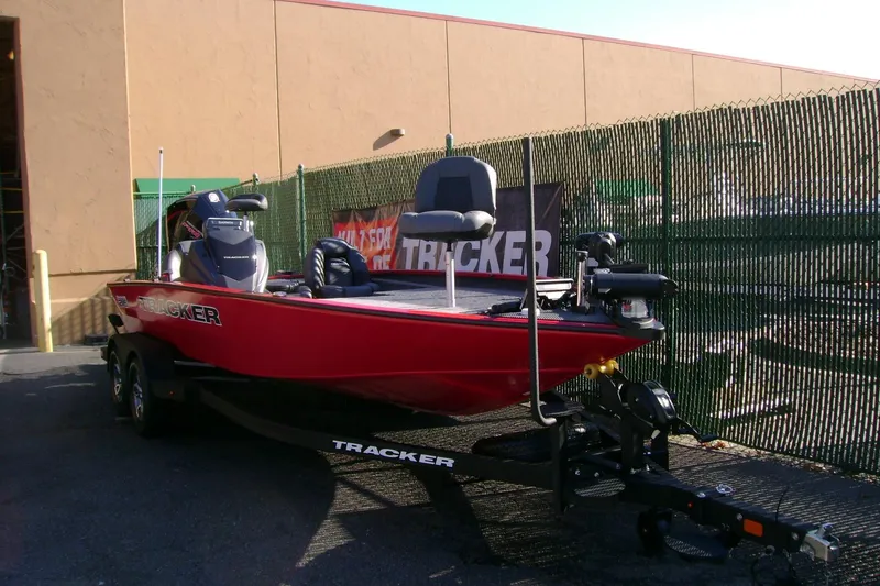 Slide: The Image of 2026 Tracker Savage 215 boat in red, parked on a trailer outside a building. - 65
