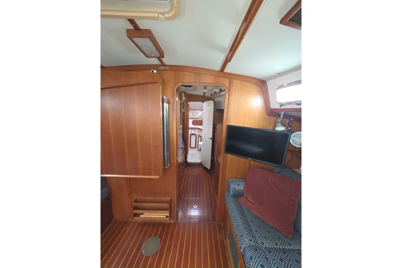 Slide: The Image of Interior of 2001 Caliber 40LRC sailboat with wood paneling and cozy seating area. - 15