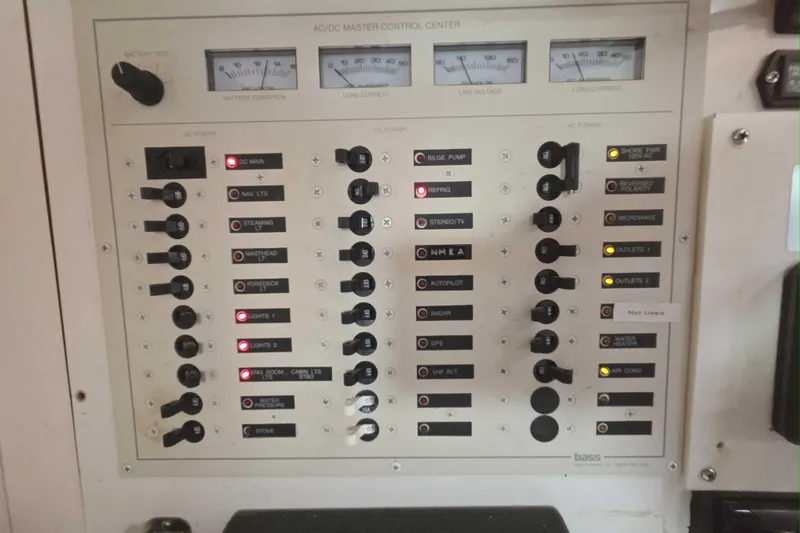 Slide: The Image of AC/DC master control panel on a 2001 Caliber 40LRC boat, showing various switches and indicators. - 21