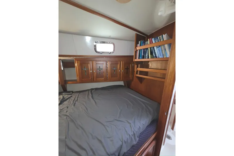 Slide: The Image of Cozy cabin interior of 2001 Caliber 40LRC with bed, wooden cabinets, and bookshelf. - 24