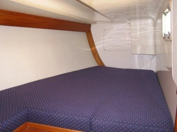Slide: The Image of Cozy cabin interior of 2001 Caliber 40LRC sailboat with blue cushioned bed. - 32