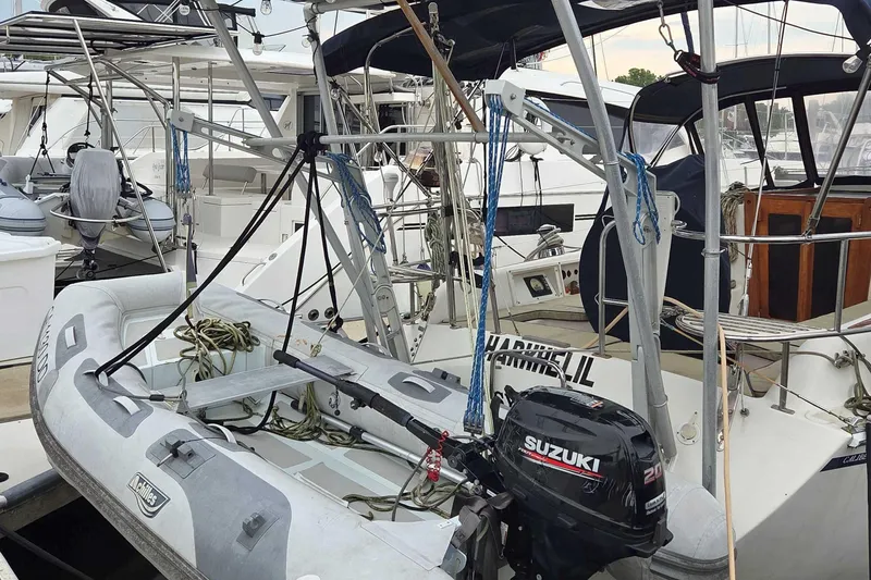 Slide: The Image of Inflatable dinghy with Suzuki outboard motor on 2001 Caliber 40LRC sailboat at marina. - 5