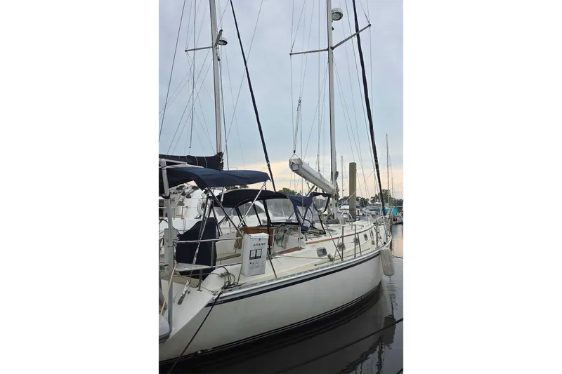 Slide: The Image of 2001 Caliber 40LRC sailboat docked at marina, featuring sleek design and tall masts. - 6