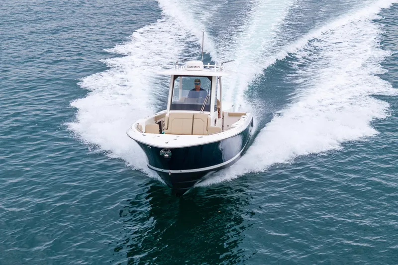 Slide: The Image of 2019 Pursuit S 288 Sport boat cruising on open water, creating a wake. - 12