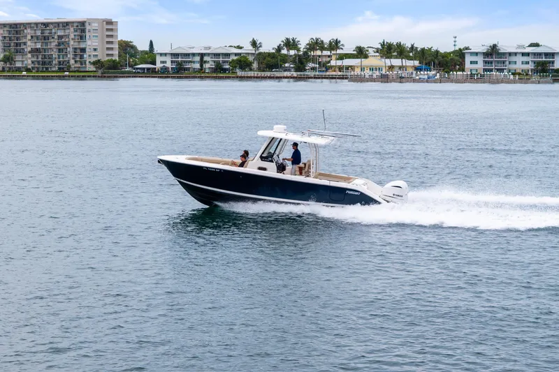 Slide: The Image of 2019 Pursuit S 288 Sport boat roof with hatch and support poles, overlooking waterfront. - 25