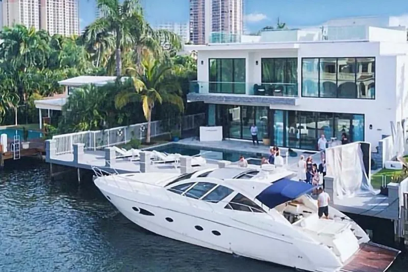Slide: The Image of Luxurious 2010 Azimut Atlantis 54 yacht docked by a modern waterfront villa. - 3