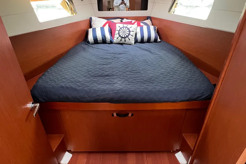 Slide: The Image of Cozy cabin interior of 2020 Beneteau Oceanis 41.1 with nautical-themed bedding. - 2