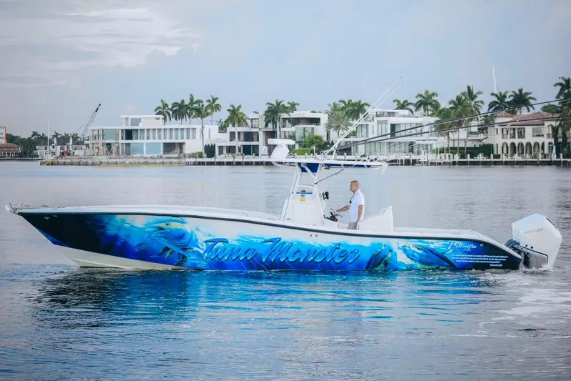 Slide: The Image of 2007 Yellowfin 36 Offshore boat with vibrant blue graphics on calm water. - 1