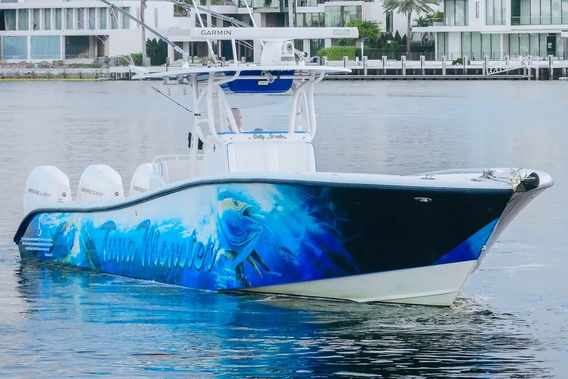 Slide: The Image of 2007 Yellowfin 36 Offshore boat with vibrant marine-themed hull design on the water. - 12