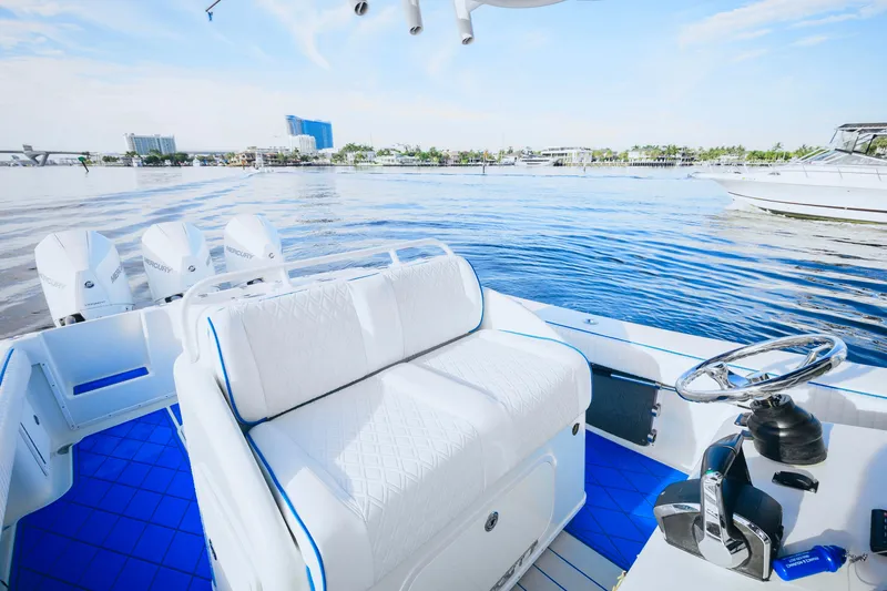 Slide: The Image of 2007 Yellowfin 36 Offshore boat interior with white seating and blue flooring on calm water. - 17