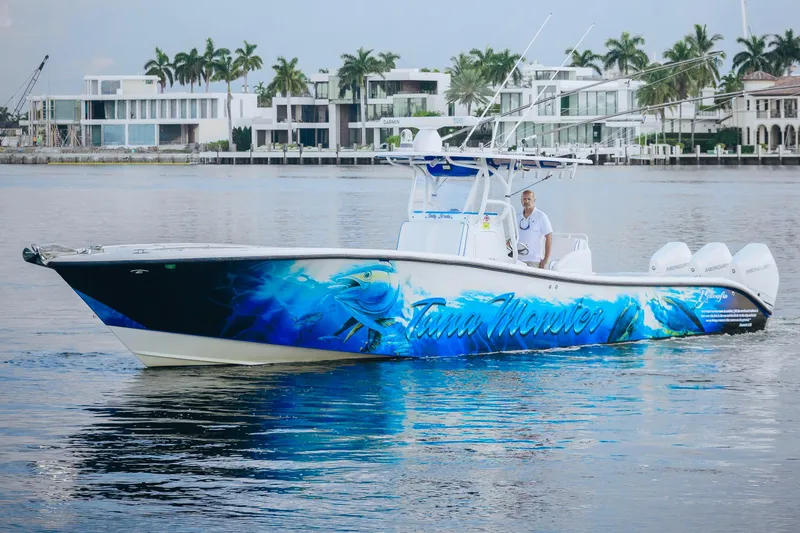 Slide: The Image of 2007 Yellowfin 36 Offshore boat with vibrant blue graphics on calm water. - 2