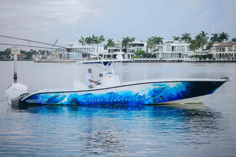 Slide: The Image of 2007 Yellowfin 36 Offshore boat with vibrant blue graphics on calm water. - 4