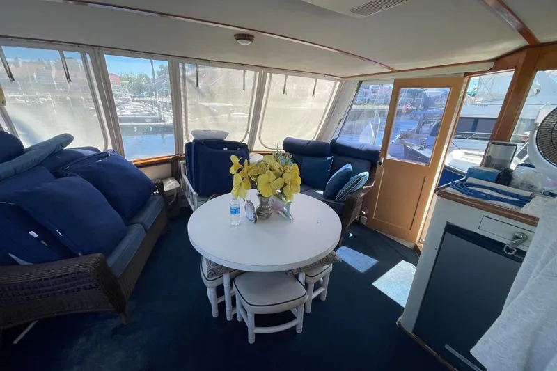 Slide: The Image of 1969 Chris-Craft 47 Commander interior with seating, table, and marina view. - 13